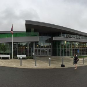 Landscape of the front of Parma Snow Public Library, all glass structure