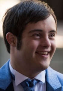 A young man with down syndrom wearing a blue suit