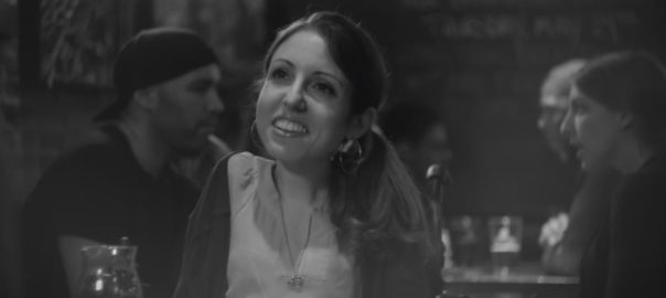 A black and white image of a woman at a table in a restaurant