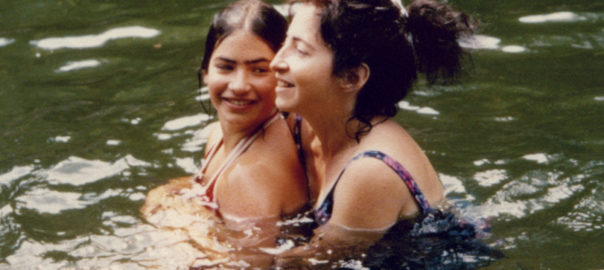 A woman holds a child in a lake