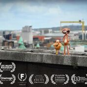 Two small colorful toys stand on top of a concrete ledge