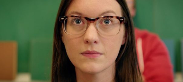 A woman with glasses look up with her eyebrows raised