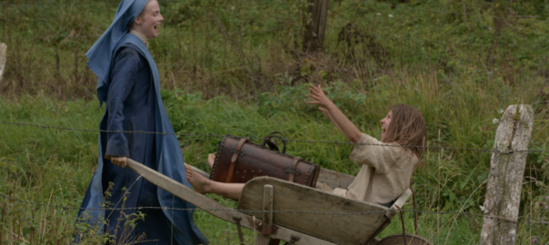 A woman pushes a person in a wheelbarrow
