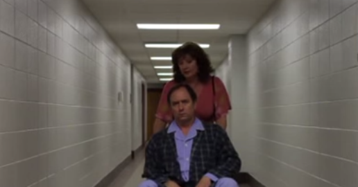 A woman pushes a man in a wheelchair