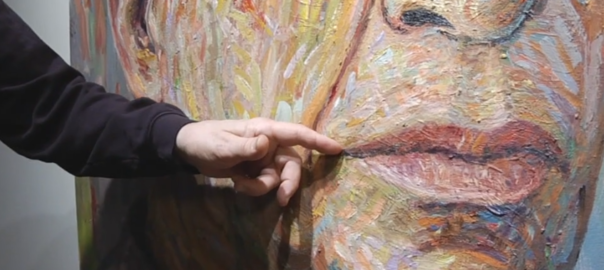 A hand points to a painting of a face