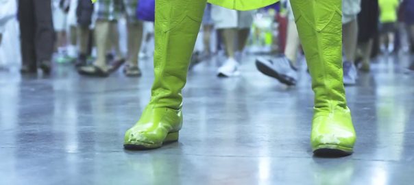Green boots and the hem of a green cape