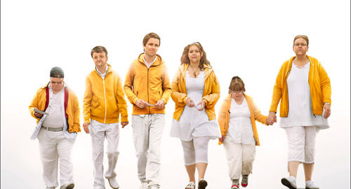 A group of people in white clothes and bright yellow jackets
