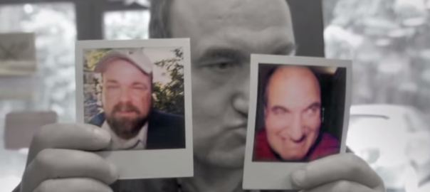 A man holds up two polaroid images