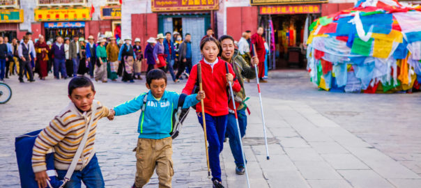 A group of children hold hands in a line