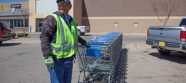 A man pushes many shopping carts