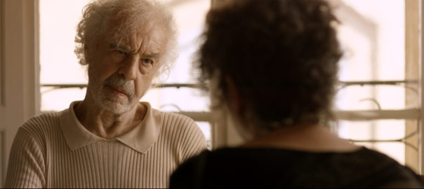 An older man looks at someone in front of him.