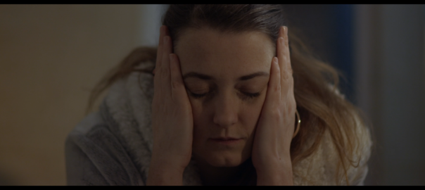 A woman holds her head in her hands
