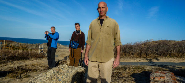 Three men walk outside