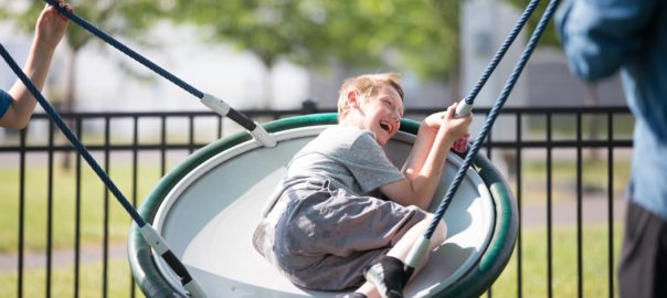 A boy swings on a large swing
