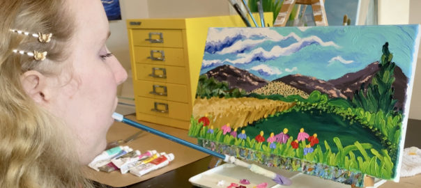 Filmmaker Grace Fisher paints a vivid landscape holding a paint brush in her mouth.