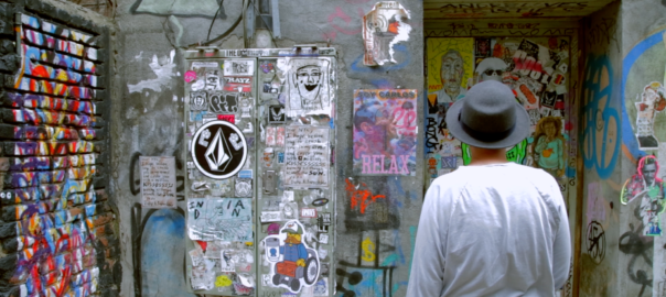 Marc Schiller faces a corner filled with drawings and graffiti.