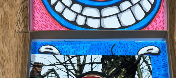 Two colorful images. On top, a smiling face with bright blue lips. A photograph of the filmmaker rests on the bottom face. He has his hands placed over his eyes.