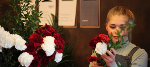 A young woman arranges a bouquet of flowers.